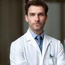 Portrait d'un dermatologue homme expérimenté, à l'air réfléchi et compétent, représentant la profondeur de l'expertise médicale.